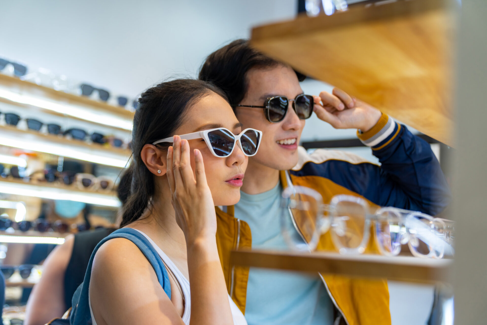 couple trying on sunglasses in store